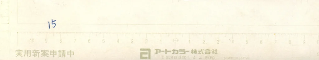 Détail macro de la marge inférieure d'une planche de manuscrit officiel de manga révélant le numéro de page 15 manuscrit et les repères d'édition sur papier professionnel japonais Art Color.